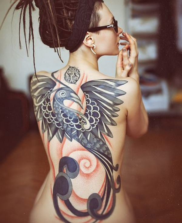 Big colored artistic bird on womens back