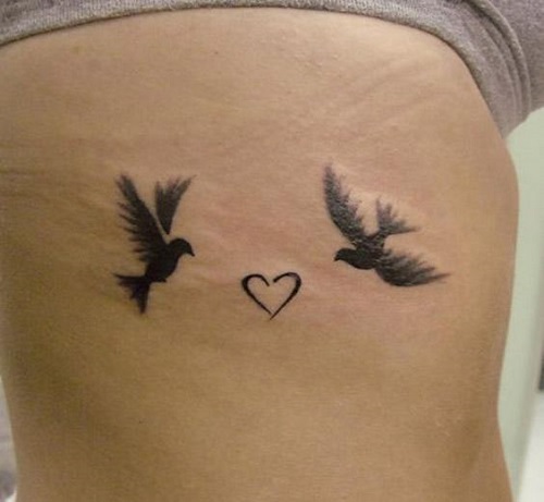 Lovebirds flying towards a heart tattoo