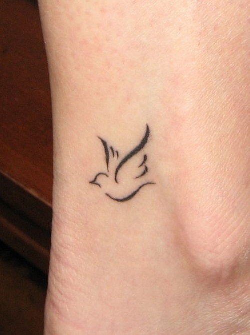 Tiny flying bird tattoo