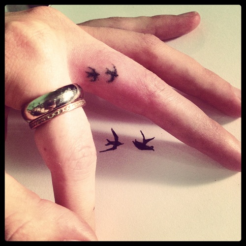 Two small birds finger tattoo