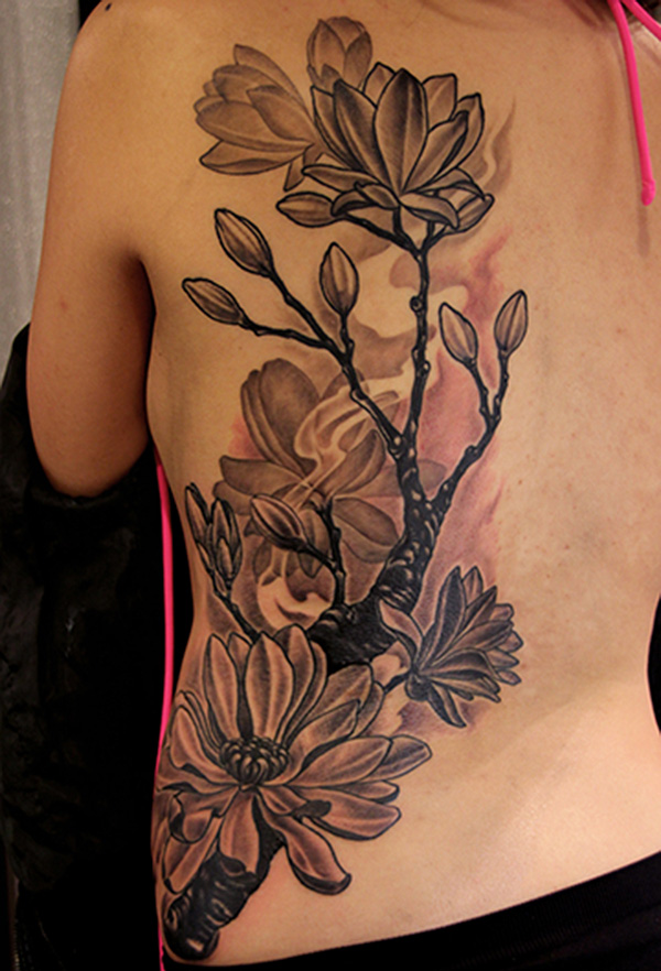 Big gray flower tattoo on half of thr back