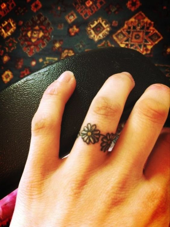 Colored flower ring like tattoo on a finger