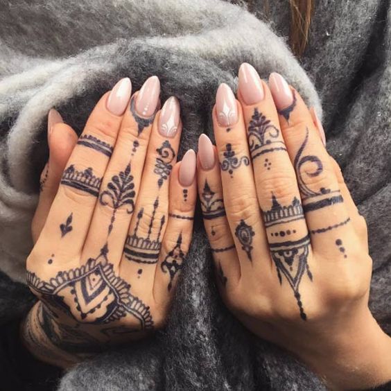 Many tattoos on all fingers and hands tribal style