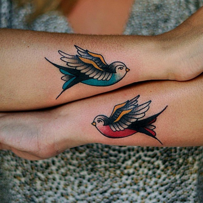 Two matched colored swallows on hands